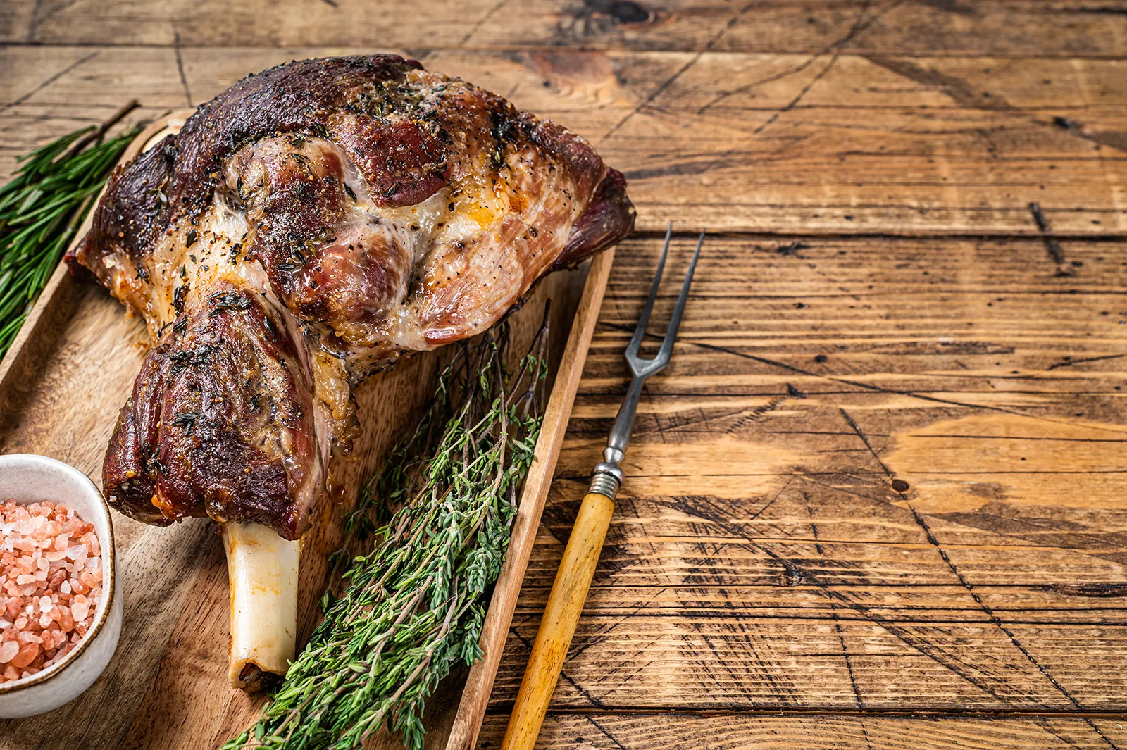 a goat leg on a wooden tray